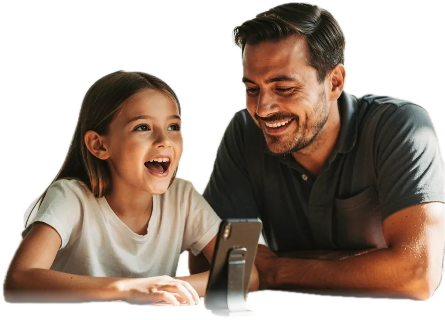 A father and his daughter at a dining table, the girl speaking toward a phone propped on a stand while he sits beside her, watching her rather than the screen