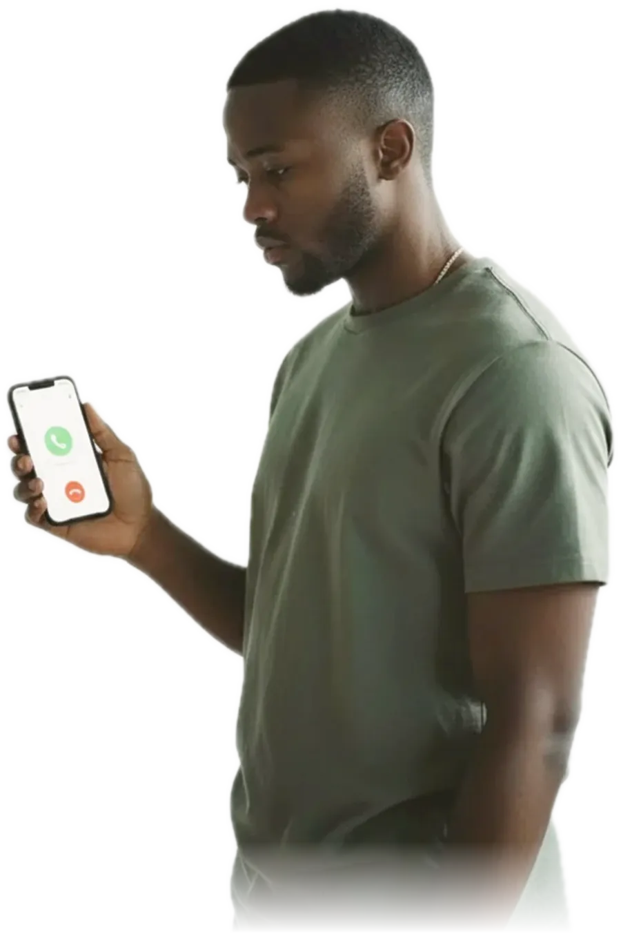 A young man standing in a hallway looking down at a ringing phone on a side table without picking it up