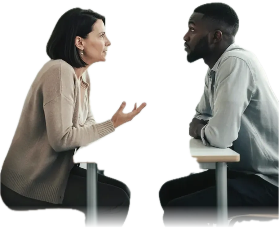 A speech and language therapist mid-explanation with a patient listening, seated facing each other in a plain therapy room